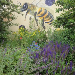 Garten mit Graffiti, das eine Honigbiene zeigt.