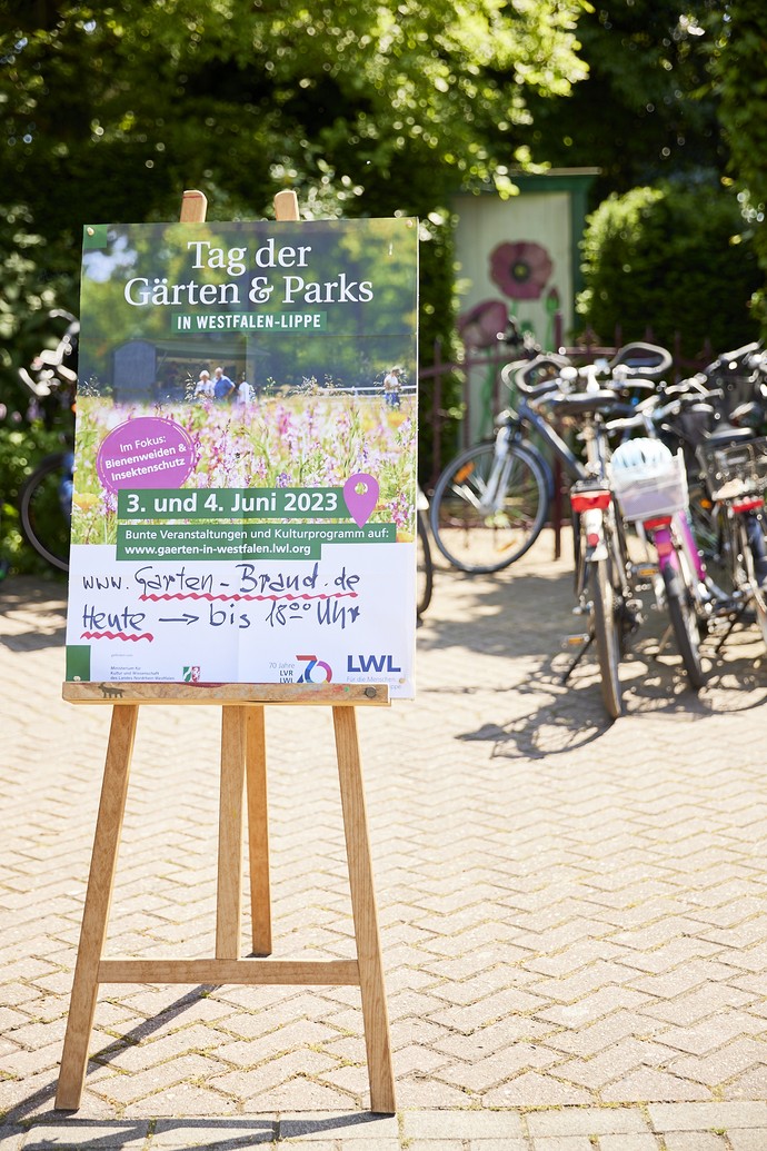 Plakat vom "Tag der Gärten und Parks in Westfalen-Lippe" mit Fahrrädern vor dem Garten Brand in Paderborn